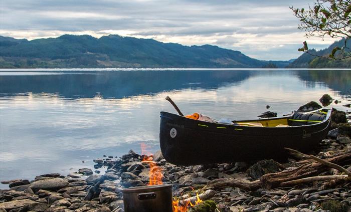 Bearded men adventures, Canoe on a Loch in Scotland next to a camp fire